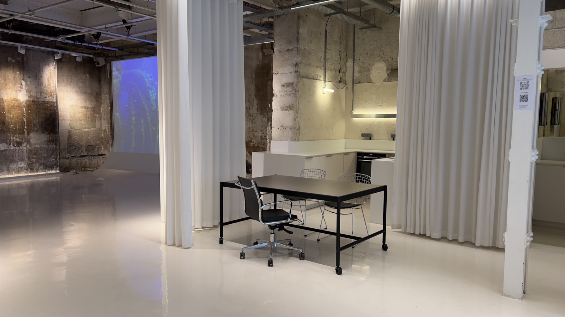 Fauteuils design colorés et table basse devant rideaux — salon Chez Les Plombiers