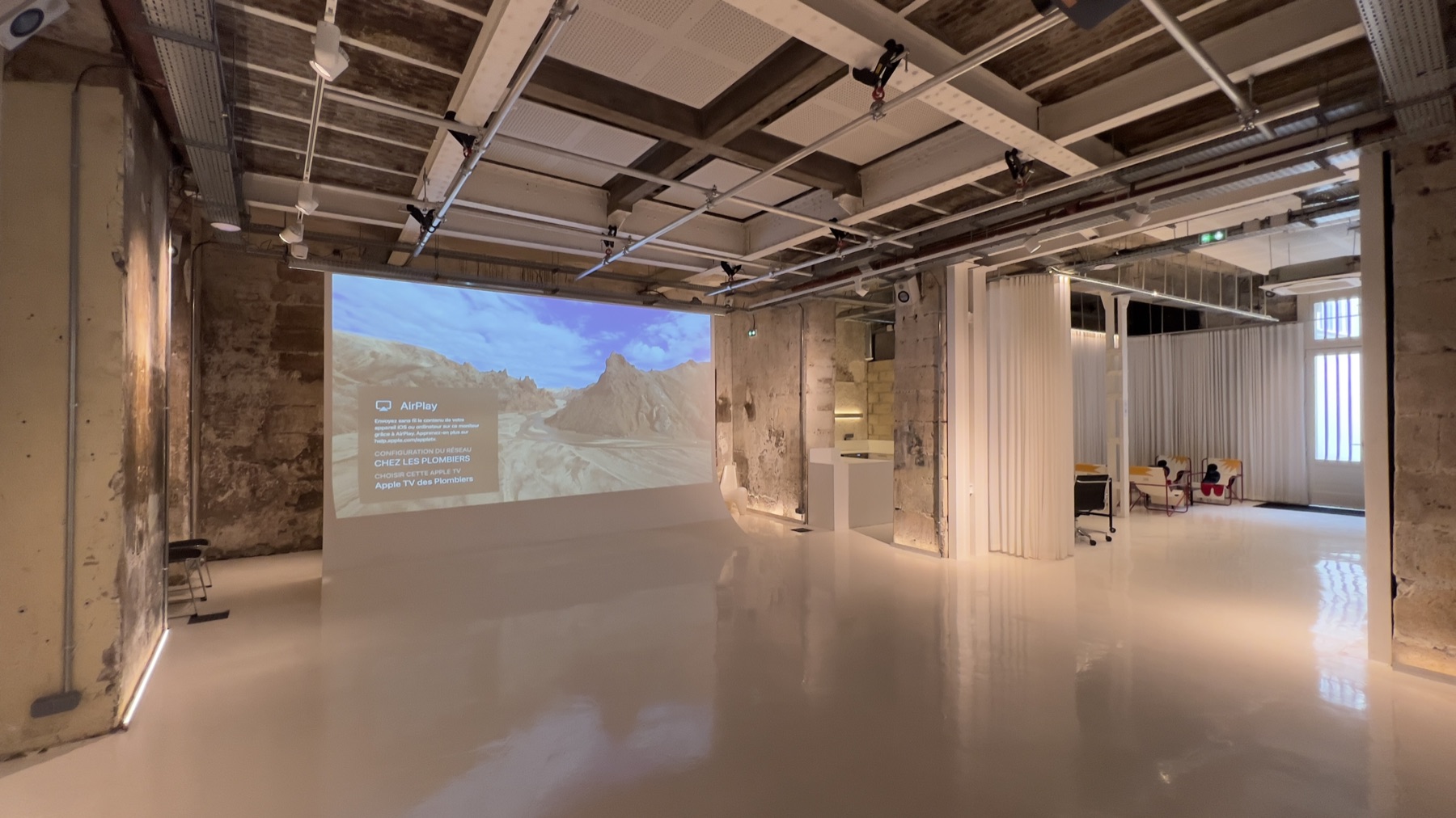Vue panoramique de la grande salle de 200 m² avec canapé rose et vidéoprojection — Chez Les Plombiers
